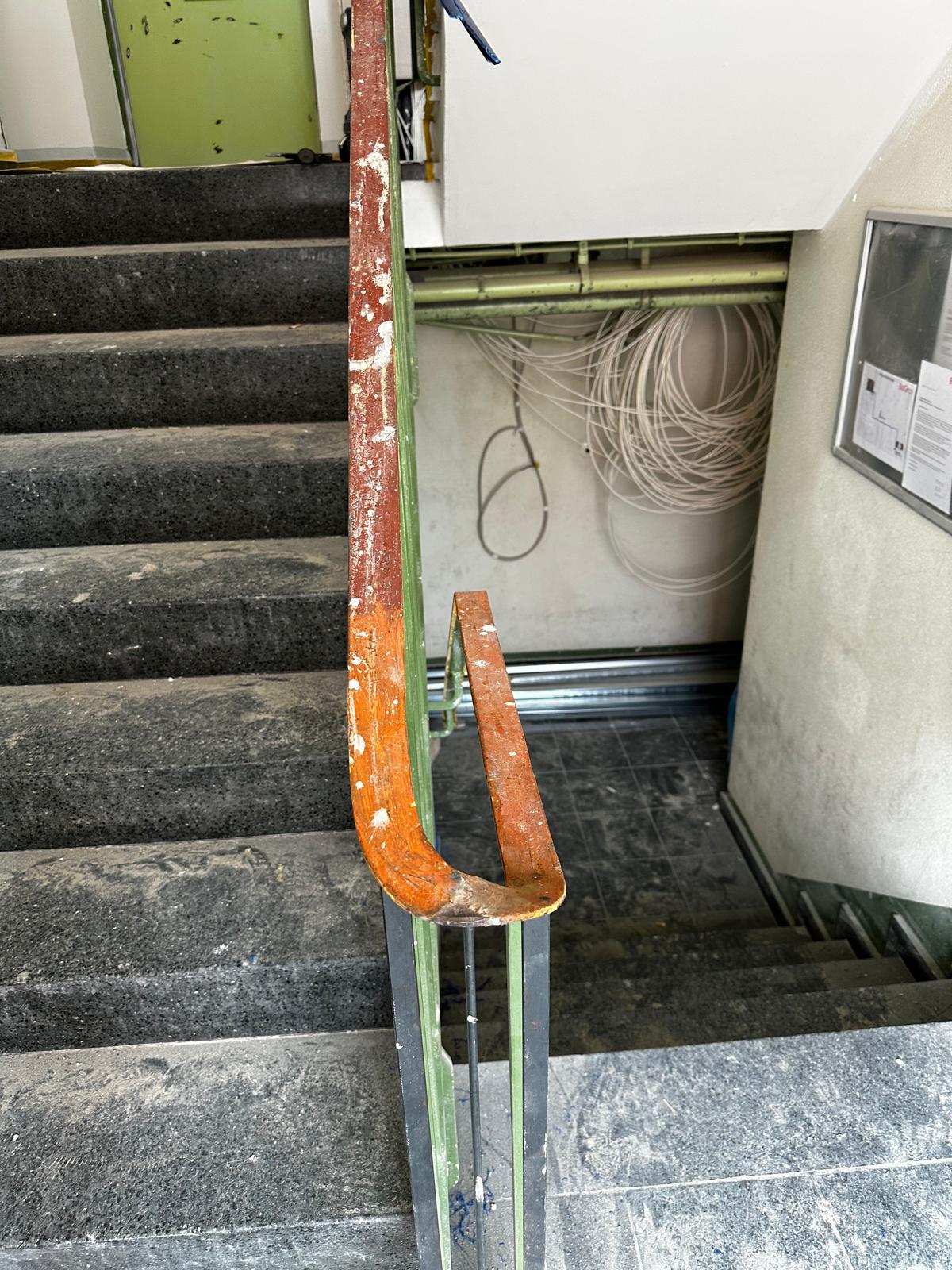 Abgenutzter und beschädigter alter Kunststoffhandlauf auf einem Treppengeländer vor der Sanierung